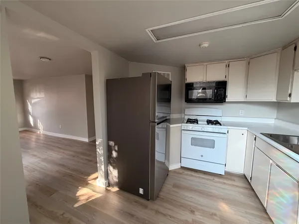 a kitchen with kitchen island a refrigerator stove and sink