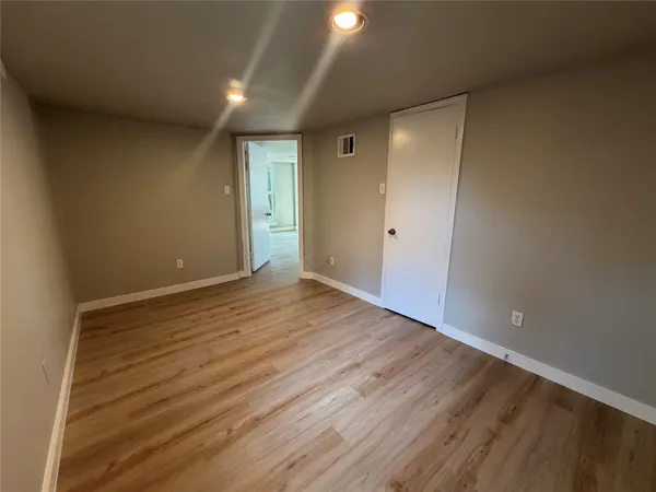 a view of an empty room with wooden floor