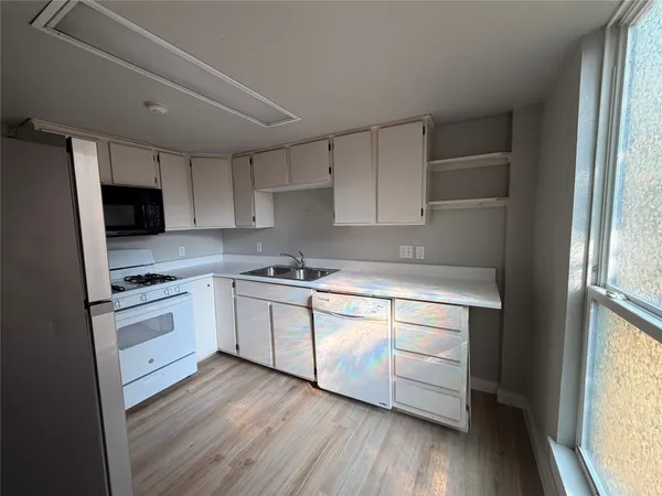 a kitchen with granite countertop white cabinets and white appliances