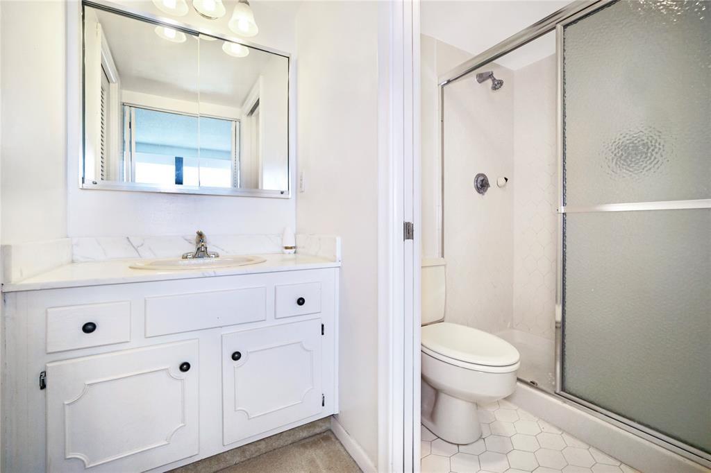 2400 Presidential Way, Unit 502 West Palm Beach, FL 33401 - Photo 13 of 28 a bathroom with a toilet a sink a vanity and mirror