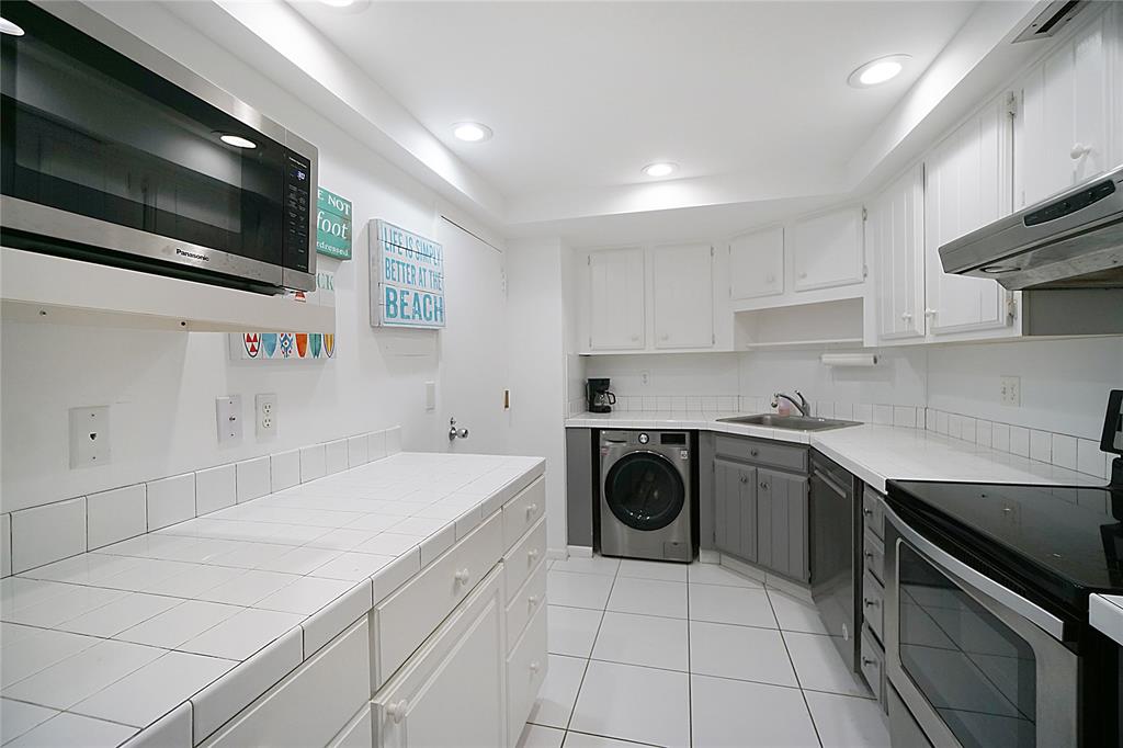 2400 Presidential Way, Unit 502 West Palm Beach, FL 33401 - Photo 5 of 28 a kitchen with a sink a stove top oven and cabinets