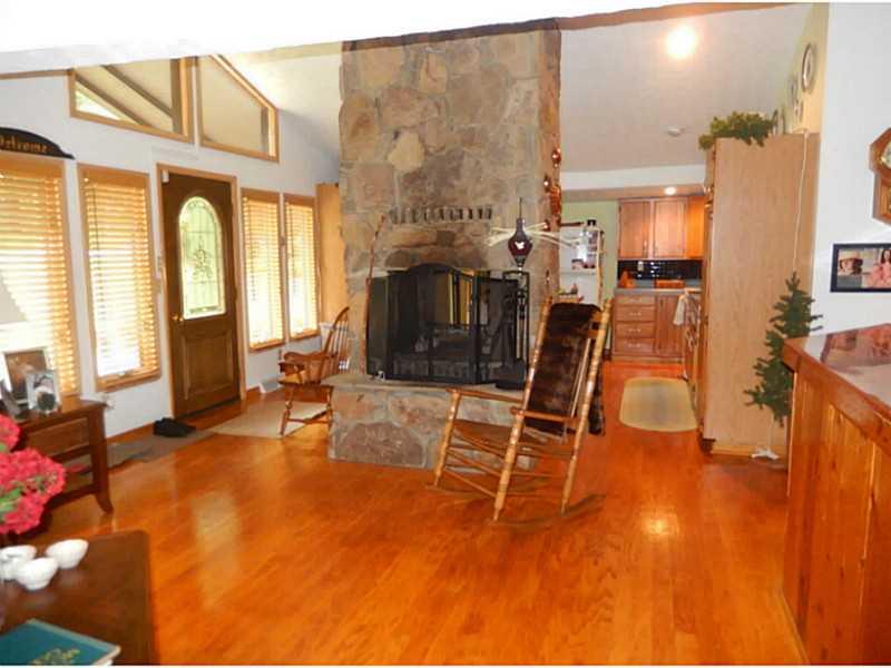 Living Room. Beautiful stone fireplace between kitchen and living room areas adds a cozy atmosphere to the rooms