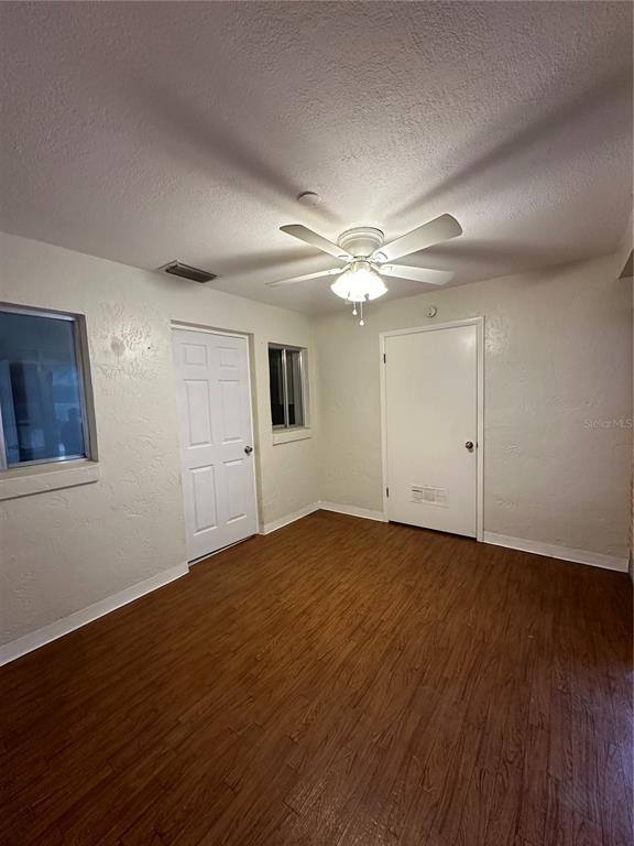 3125 Villa Road Sebring, FL 33870 - Photo 11 of 13 a view of an empty room with wooden floor and a ceiling fan