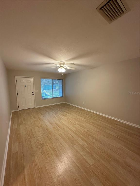 3125 Villa Road Sebring, FL 33870 - Photo 2 of 13 an empty room with wooden floor and windows