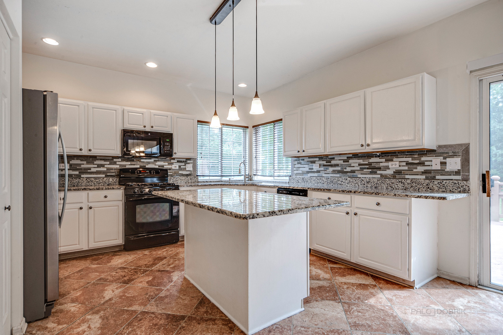 185 Aberdeen Drive Algonquin, IL 60102 - Photo 12 of 36 a kitchen with kitchen island granite countertop a stove a sink and a microwave