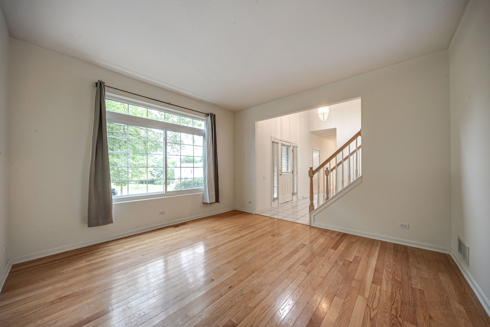 185 Aberdeen Drive Algonquin, IL 60102 - Photo 6 of 36 a view of an empty room with wooden floor and a window