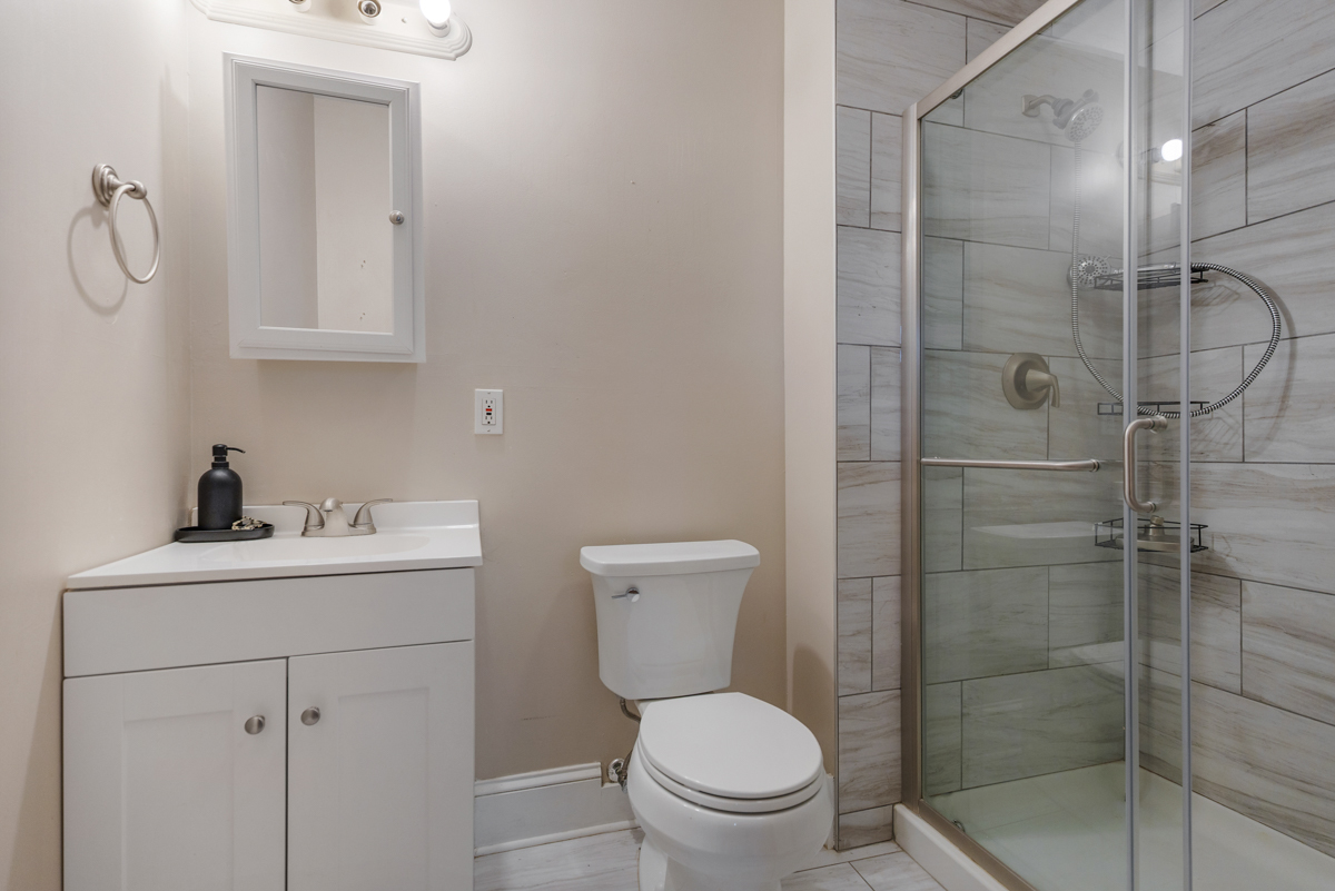 222 West Main Street, Unit A St. Charles, IL 60174 - Photo 15 of 17 a bathroom with a toilet sink vanity and shower