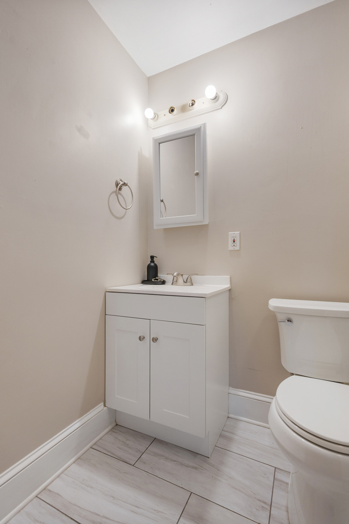 222 West Main Street, Unit A St. Charles, IL 60174 - Photo 16 of 17 a bathroom with a toilet sink vanity and mirror