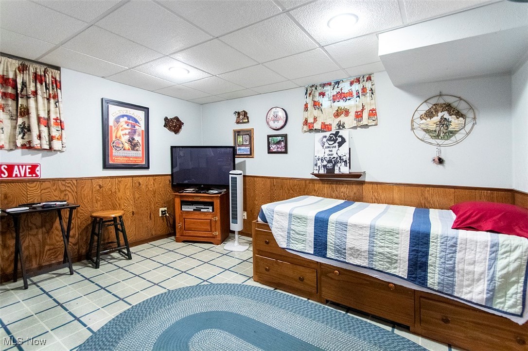 20749 Albion Road Strongsville, OH 44149 - Photo 26 of 35 Basement featuring a paneled ceiling, wooden walls, light tile patterned flooring, and wainscoting