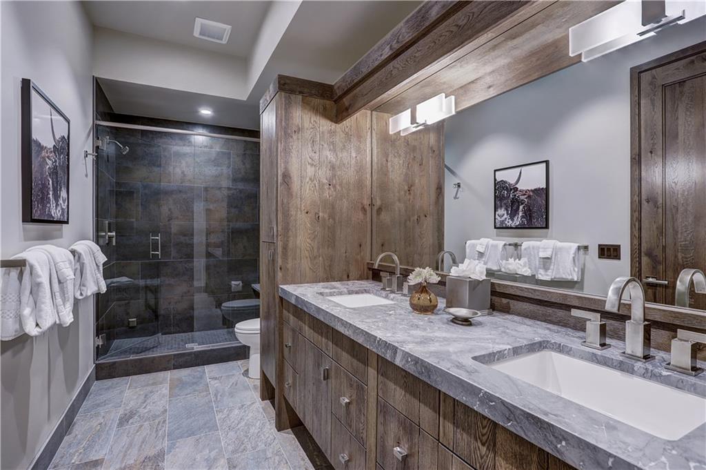 121 Boulder Circle Breckenridge, CO 80424 - Photo 29 of 35 a bathroom with double vanity sinks a large mirror and a shower