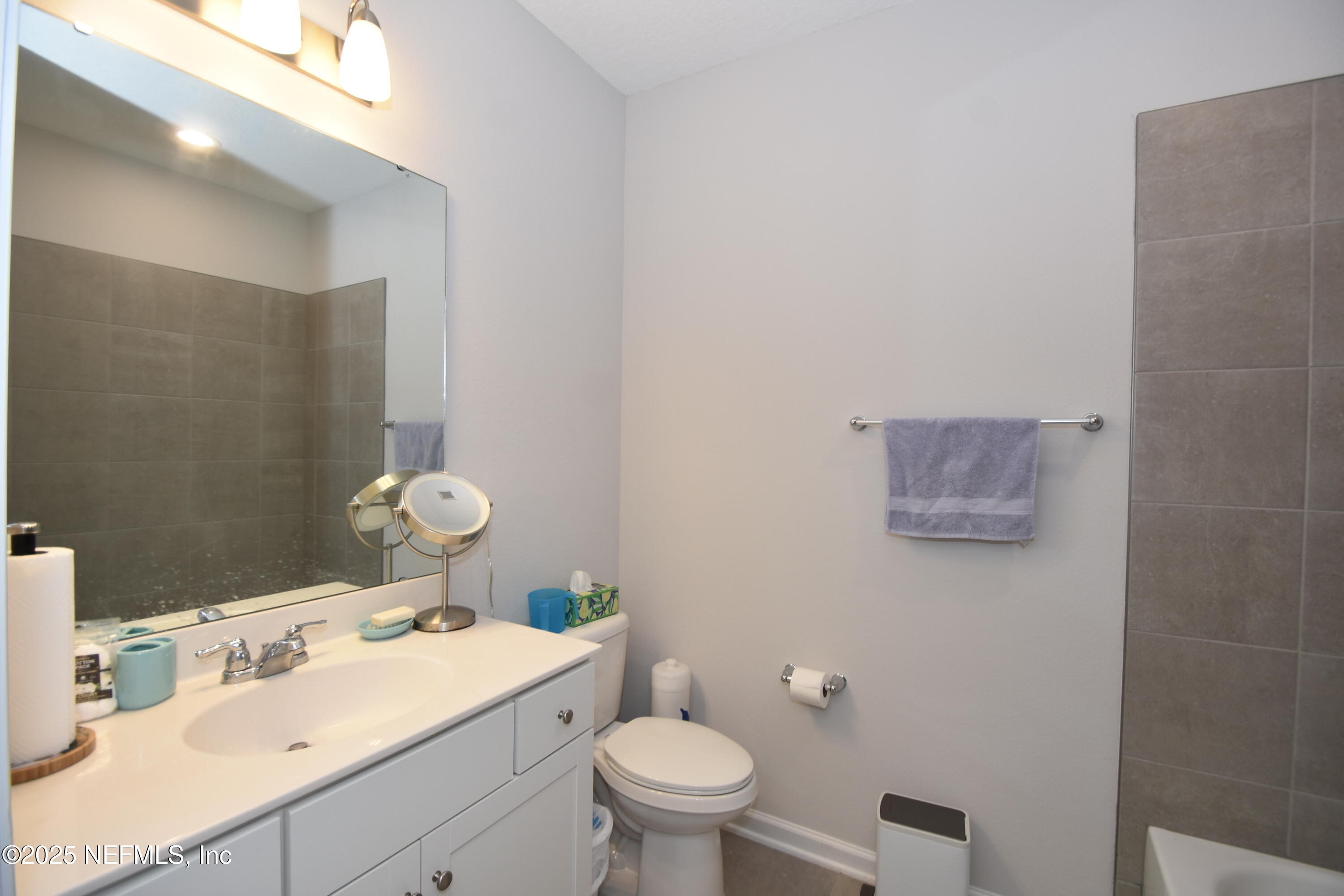 172 Charlie Way St. Augustine, FL 32095 - Photo 22 of 29 a bathroom with a granite countertop sink a toilet and a mirror