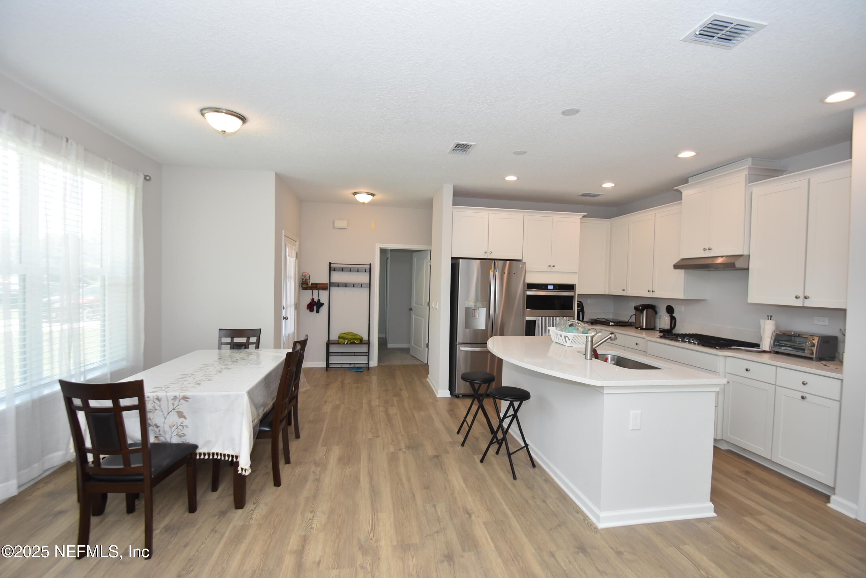 172 Charlie Way St. Augustine, FL 32095 - Photo 5 of 29 a kitchen with stainless steel appliances kitchen island granite countertop a dining table chairs and a refrigerator