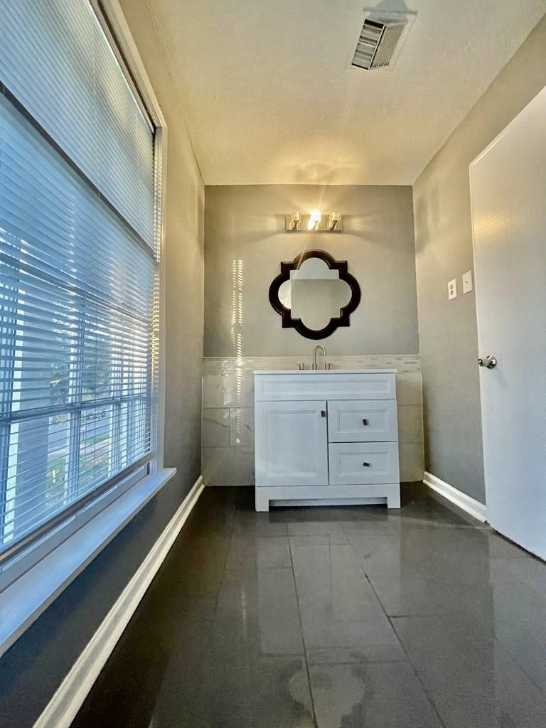 4715 Stage Road Memphis, TN 38128 - Photo 17 of 22 a bathroom with a granite countertop sink a mirror and a shower