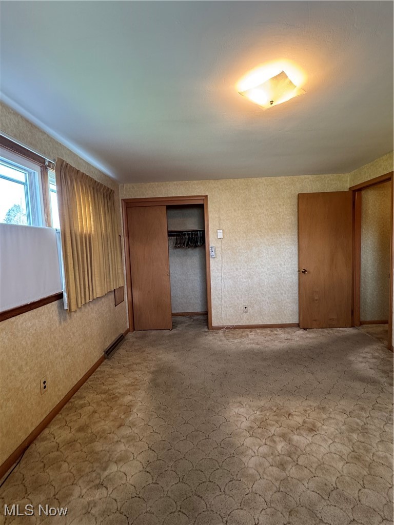3919 New Road Youngstown, OH 44515 - Photo 8 of 16 Unfurnished bedroom featuring a closet, visible vents, baseboards, and wallpapered walls