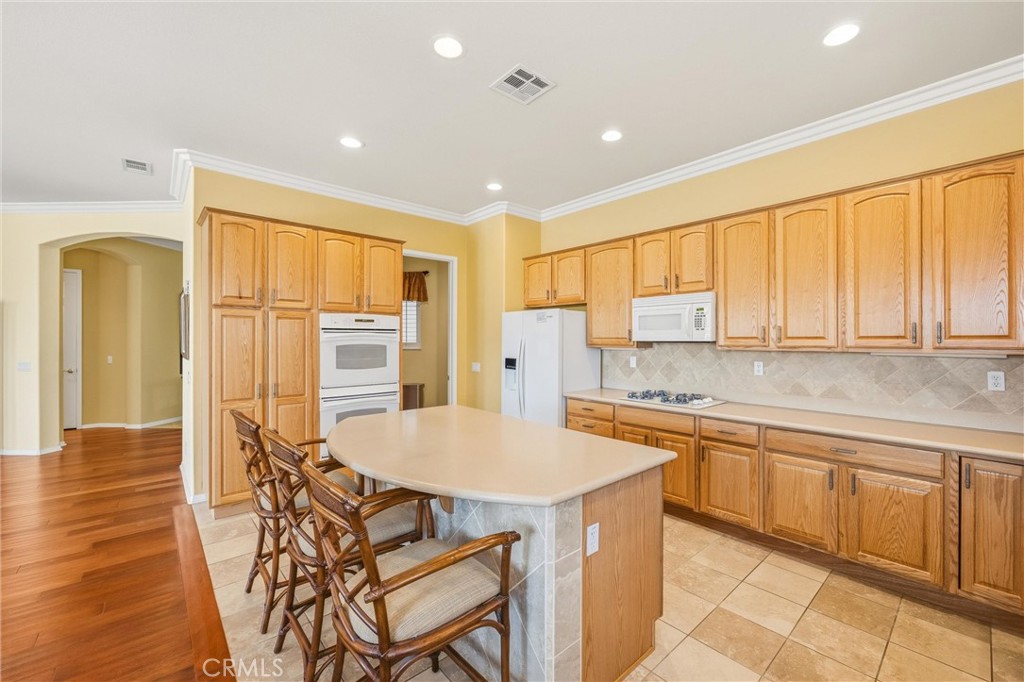 1732 Brittney Road Beaumont, CA 92223 - Photo 15 of 54 a kitchen with stainless steel appliances granite countertop a stove a sink and a refrigerator