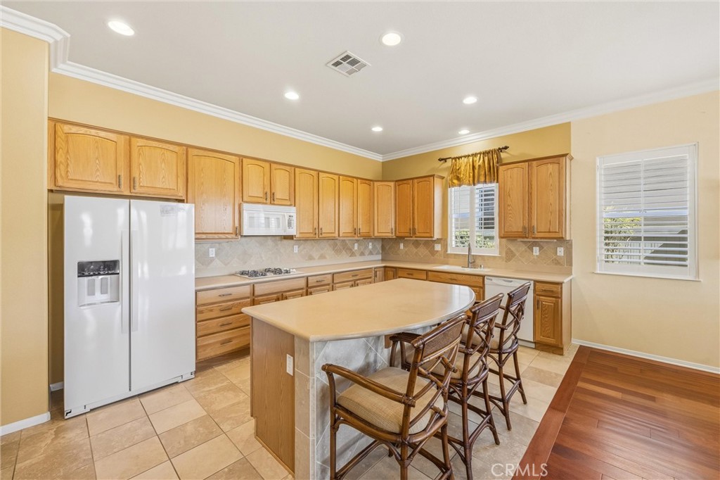 1732 Brittney Road Beaumont, CA 92223 - Photo 16 of 54 a kitchen with a table chairs refrigerator and cabinets
