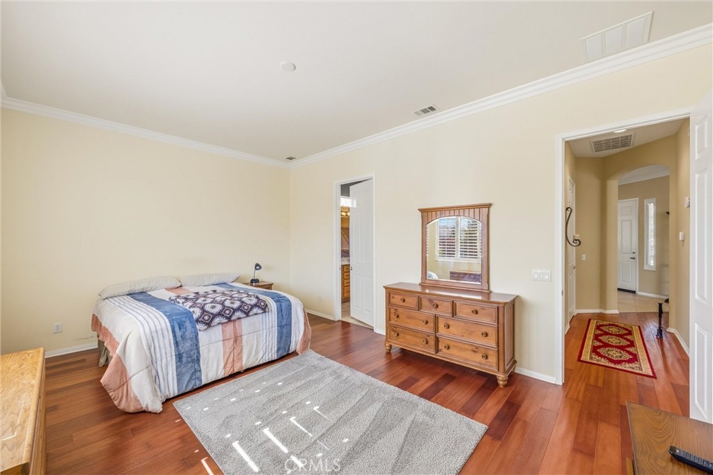 1732 Brittney Road Beaumont, CA 92223 - Photo 23 of 54 a spacious bedroom with a bed and wooden floor