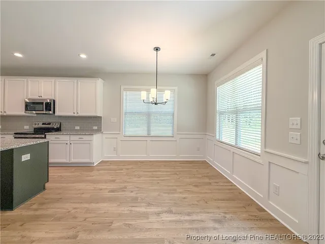 a kitchen with kitchen island granite countertop a sink a counter top space and stainless steel appliances