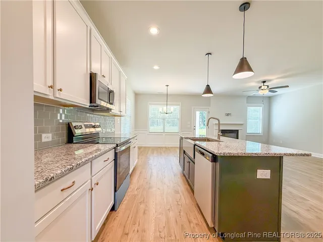 a view of a room with wooden floor and kitchen view
