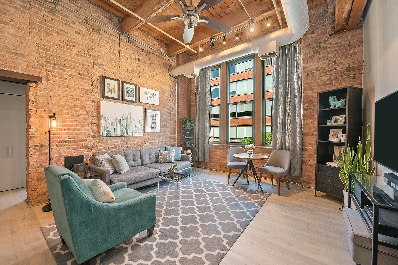 331 South Peoria Street, Unit 303 Chicago, IL 60607 - Photo 12 of 25 a living room with furniture a flat screen tv and a bookshelf