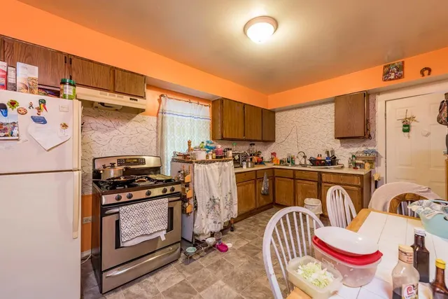 a kitchen with stainless steel appliances granite countertop a refrigerator and a stove top oven