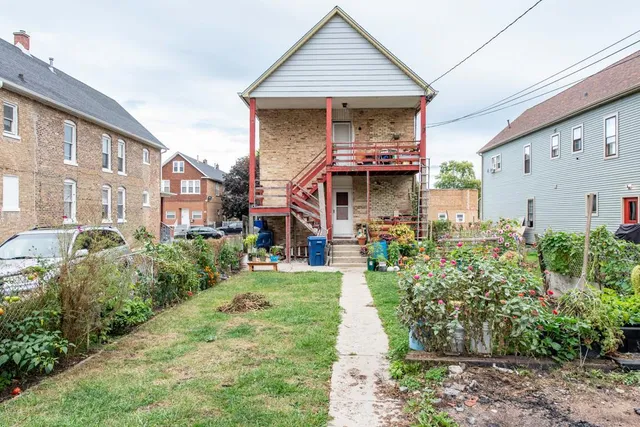 a front view of a house with a garden and trees