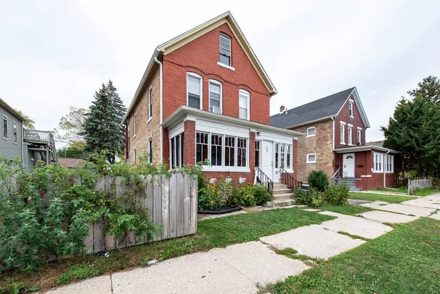a front view of a house with a yard and trees