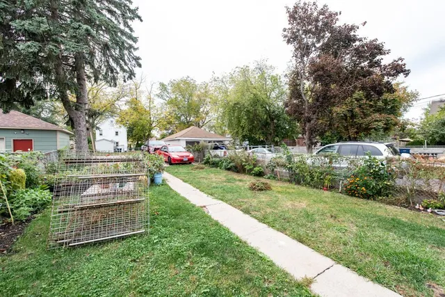 a view of a yard with plants and a table and chairs