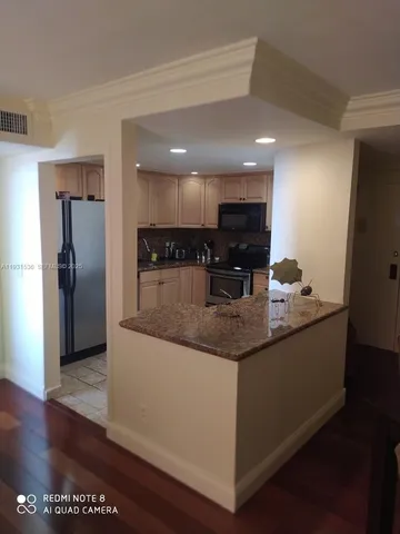 a kitchen with stainless steel appliances granite countertop a sink and a refrigerator