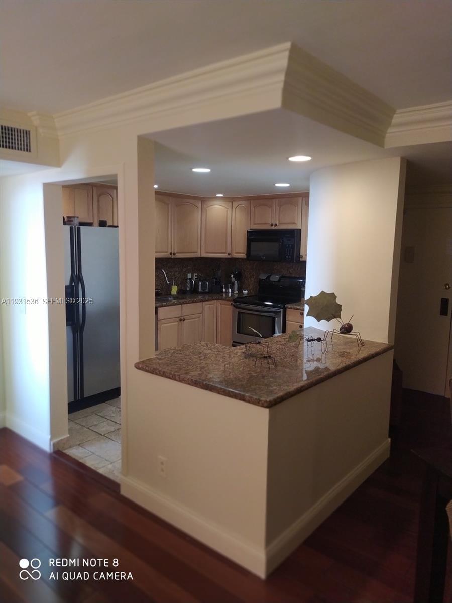 200 Southeast 15th Road, Unit 7F Miami, FL 33129 - Photo 2 of 2 a kitchen with stainless steel appliances granite countertop a sink and a refrigerator