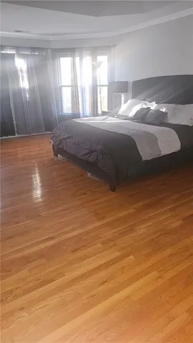 a view of a bedroom with wooden floor and windows