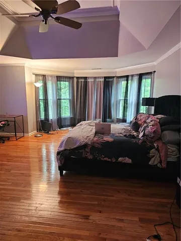 a large bedroom with a bed and wooden floor