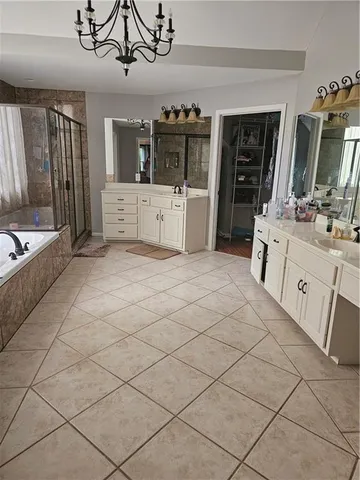 a large white kitchen with a sink and dishwasher a stove top oven with wooden floor