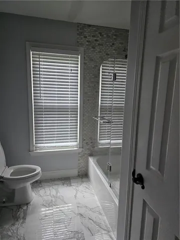a bathroom with a granite countertop toilet a sink and a bathtub