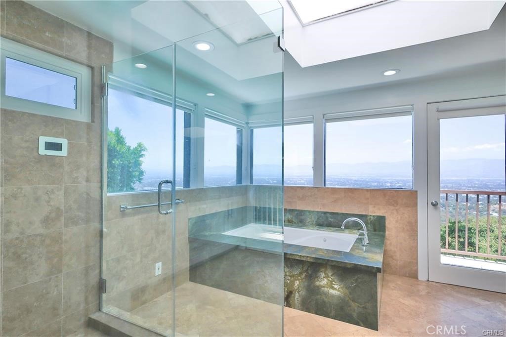 13425 Java Drive Beverly Hills, CA 90210 - Photo 7 of 28 a bathroom with a glass shower door and a bathtub