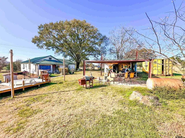 a view of a house with a yard and sitting area