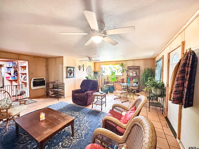 a living room with furniture a flat screen tv and a dining table