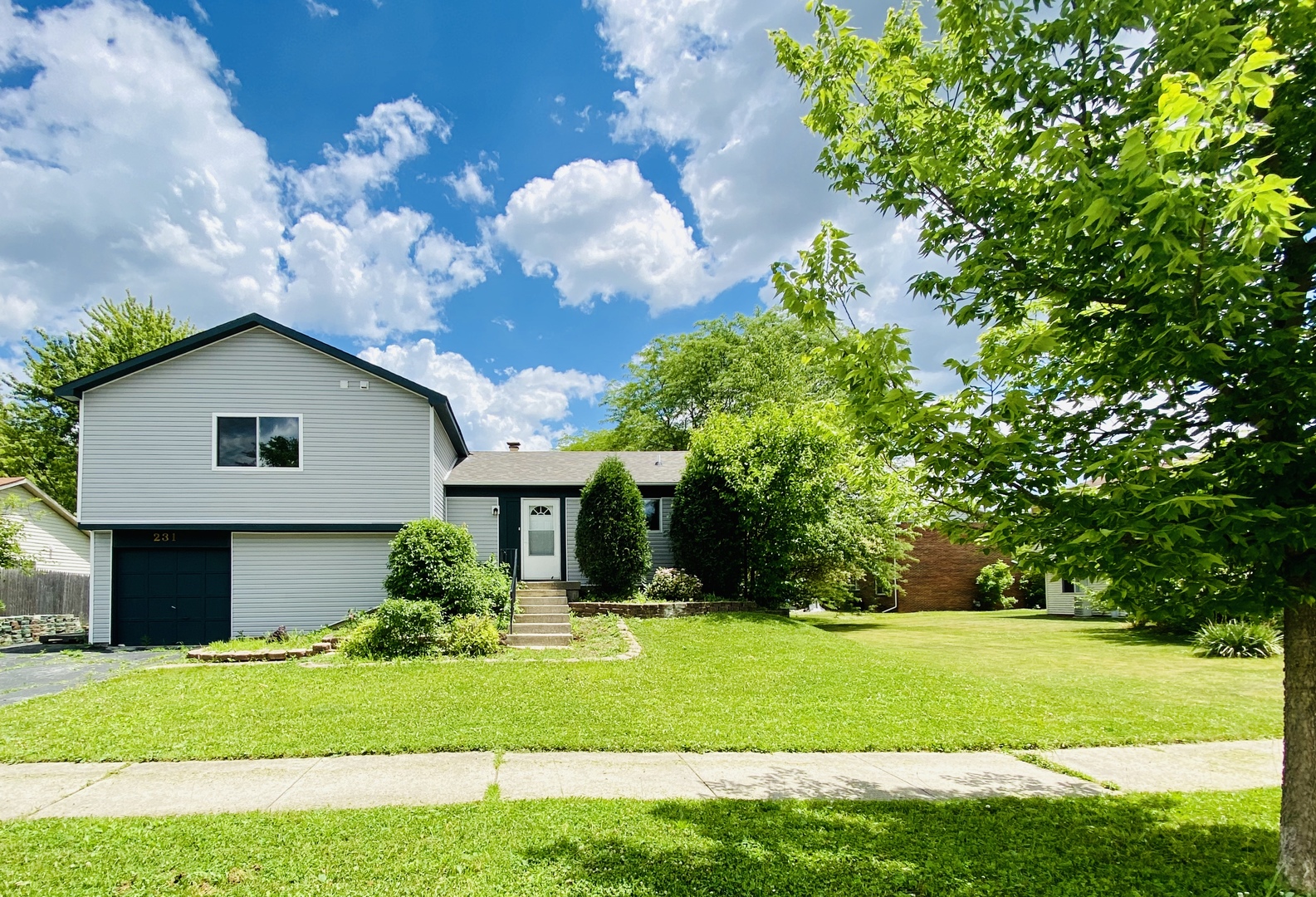 231 Oakhurst Road Matteson, IL 60443 - Photo 1 of 8 a front view of a house with garden