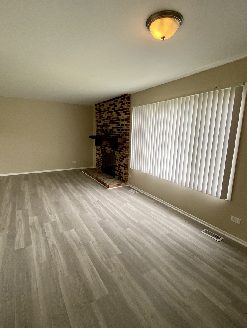231 Oakhurst Road Matteson, IL 60443 - Photo 3 of 8 an empty room with wooden floor and windows