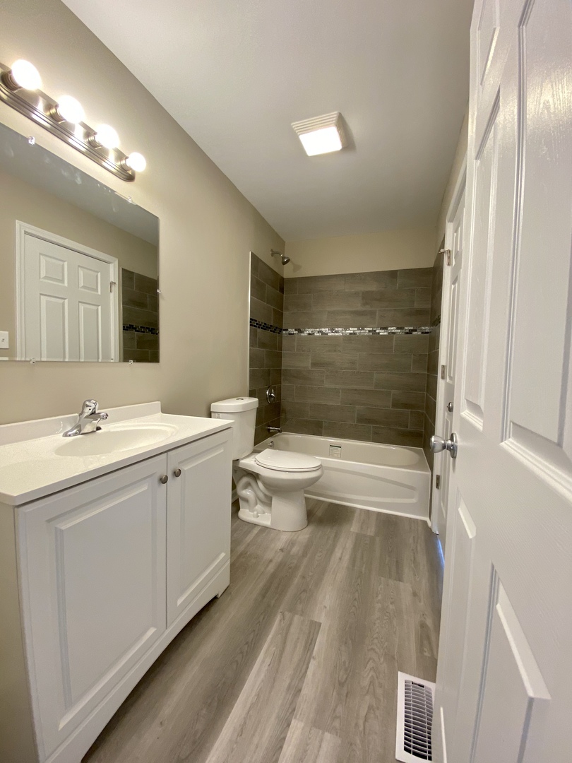 231 Oakhurst Road Matteson, IL 60443 - Photo 5 of 8 a bathroom with a double vanity sink toilet mirror and bathtub