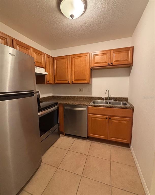 6519 West Newberry Road, Unit 604 Gainesville, FL 32605 - Photo 3 of 13 a kitchen with a refrigerator a stove top oven a sink and cabinets