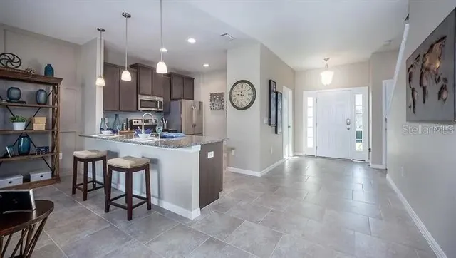a kitchen with kitchen island a large counter top space appliances and a view of living room