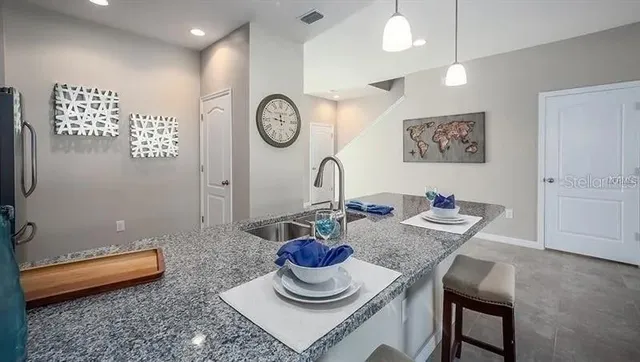 a living room with furniture a rug and kitchen view