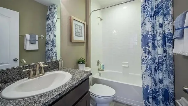 a bedroom with a bed a mirror and next to a window