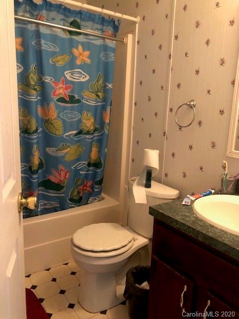 1431 Minter Road Chester, SC 29706 - Photo 7 of 11 a bathroom with a granite countertop toilet and a shower curtain