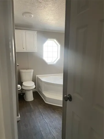 a bathroom with a toilet a sink and mirror