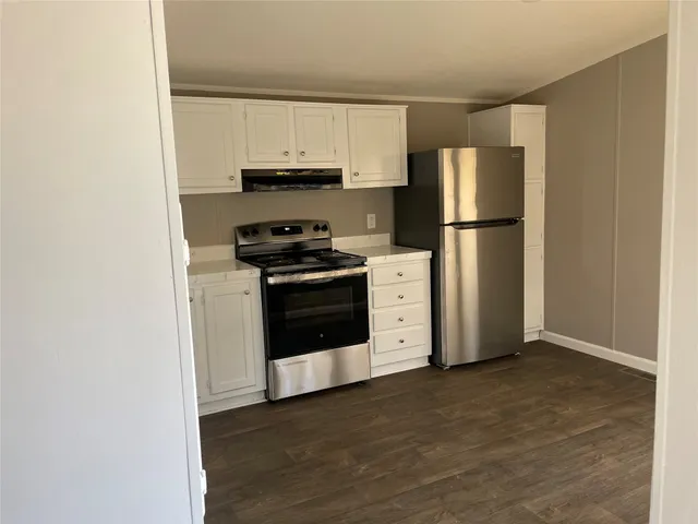 a kitchen with white cabinets and stainless steel appliances