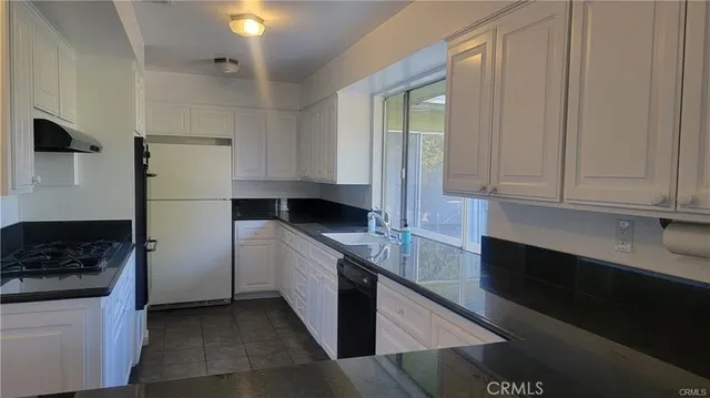 a kitchen with a refrigerator and a sink