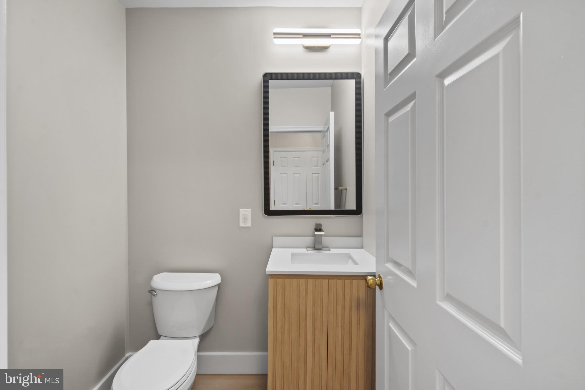 100 Harborview Drive, Unit 1312 Baltimore, MD 21230 - Photo 12 of 37 a bathroom with a granite countertop toilet sink and mirror