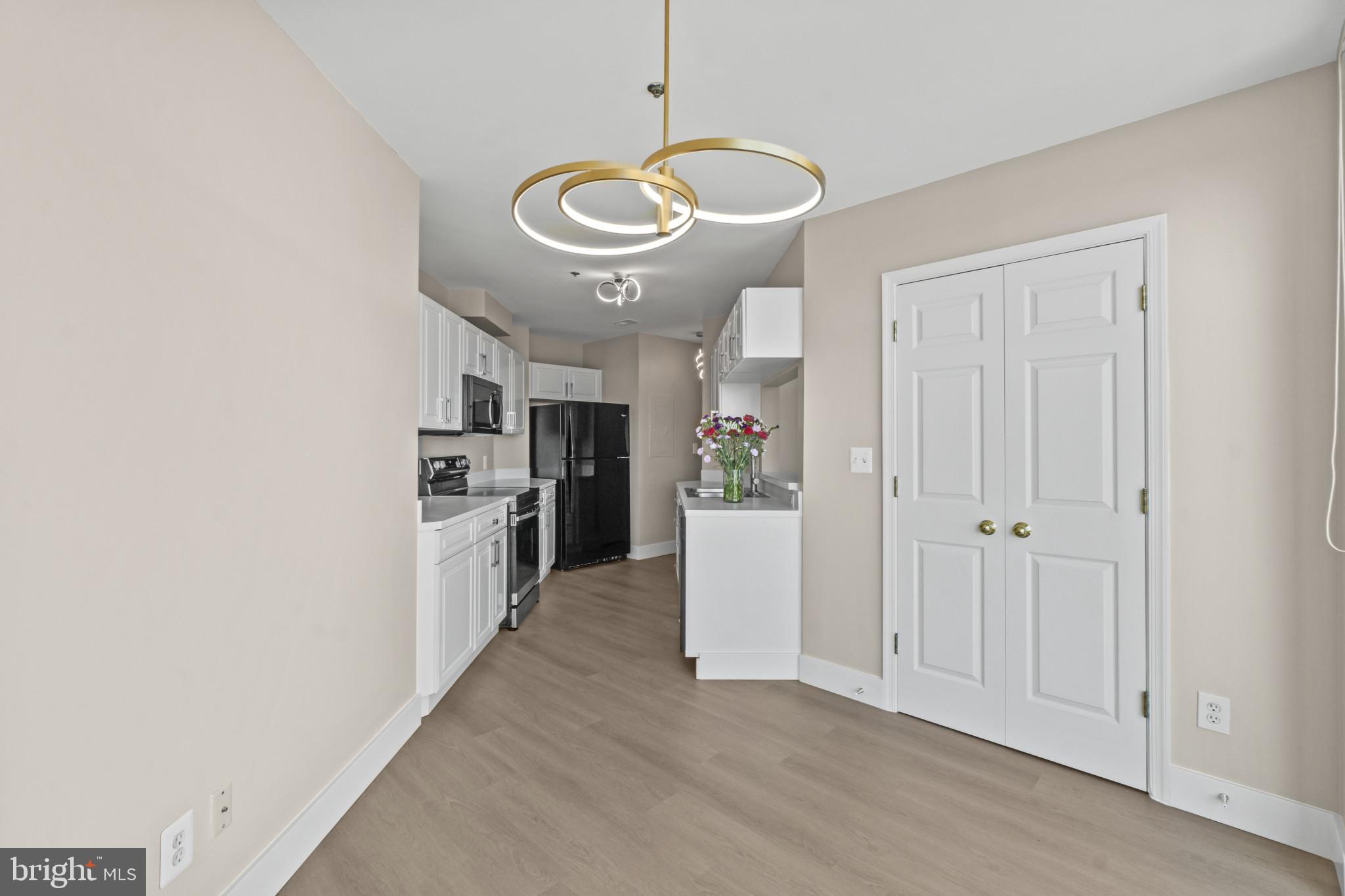 100 Harborview Drive, Unit 1312 Baltimore, MD 21230 - Photo 18 of 37 a view of a kitchen with a sink and dishwasher a refrigerator with wooden floor